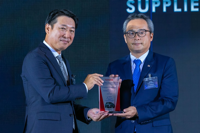 Mr. Yoshiyuki Takai, Executive Vice President of Toyota Daihatsu Engineering & Manufacturing Co., Ltd. (left) presented the award, “2022 Outstanding Performance Supplier for Early Achievement of 2025 Target in Environment (CO2 Reduction)” to Mr. Shigeho Kumano, OE Business Director of Thai Bridgestone Co., Ltd. (right)